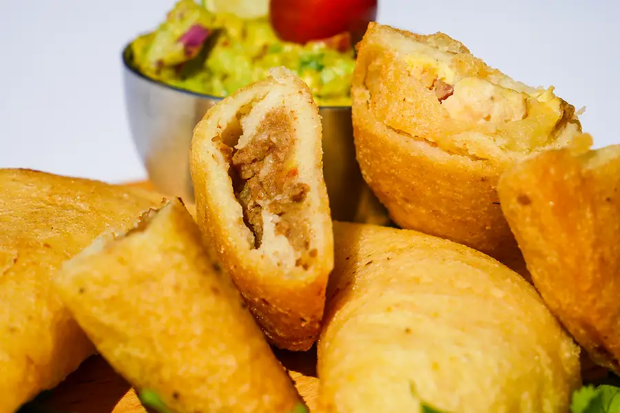 Une pile d'empanadas, dont une ouverte sur sa garniture